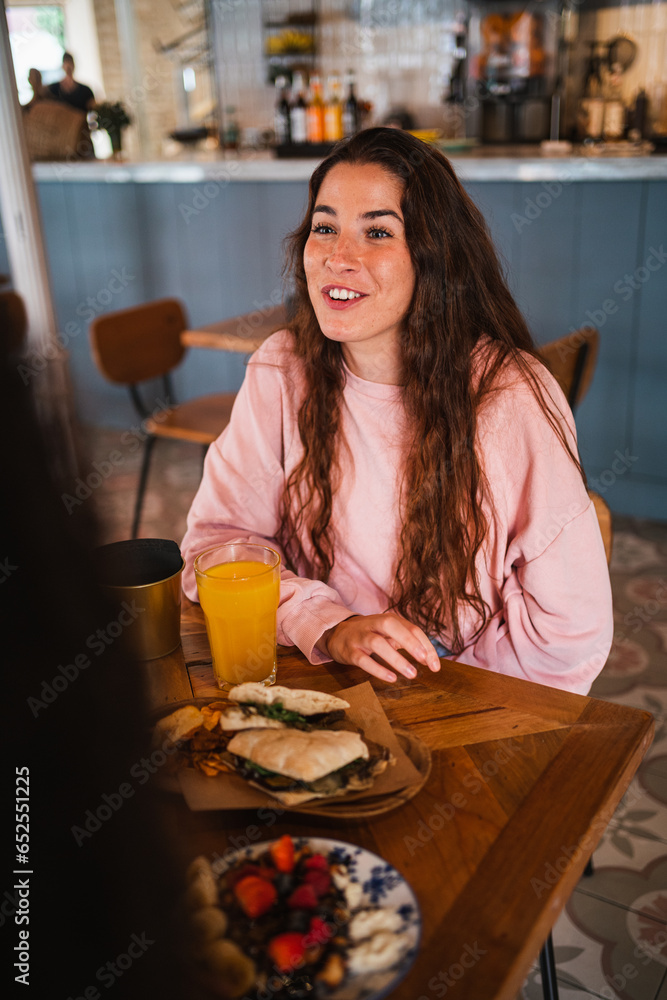 Happy young woman having fun with her friends sitting at a brunch cafe restaurant Happy young woman having fun with her friends sitting at a brunch cafe restaurant