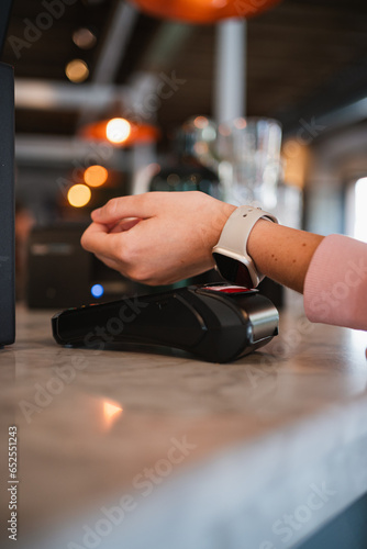 Close up shot of hand paying wireless on a POS with a smart watch at a restaurant
