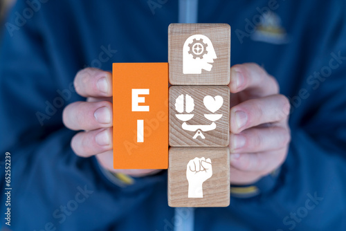 Hands holding colorful blcoks with icons and abbreviation: EI. Emotional and intelligence quotient. EI Emotional Intelligence business concept in management. photo