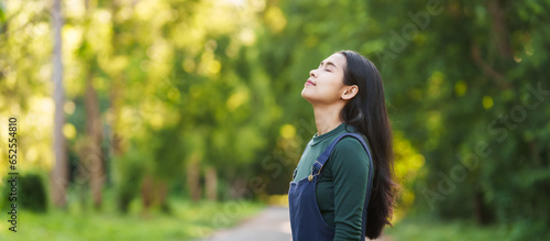Photos Happy young Asian woman relaxing outdoors, Enjoy beauty of nature and find inner peace on a sunny afternoon, relax time, love your self