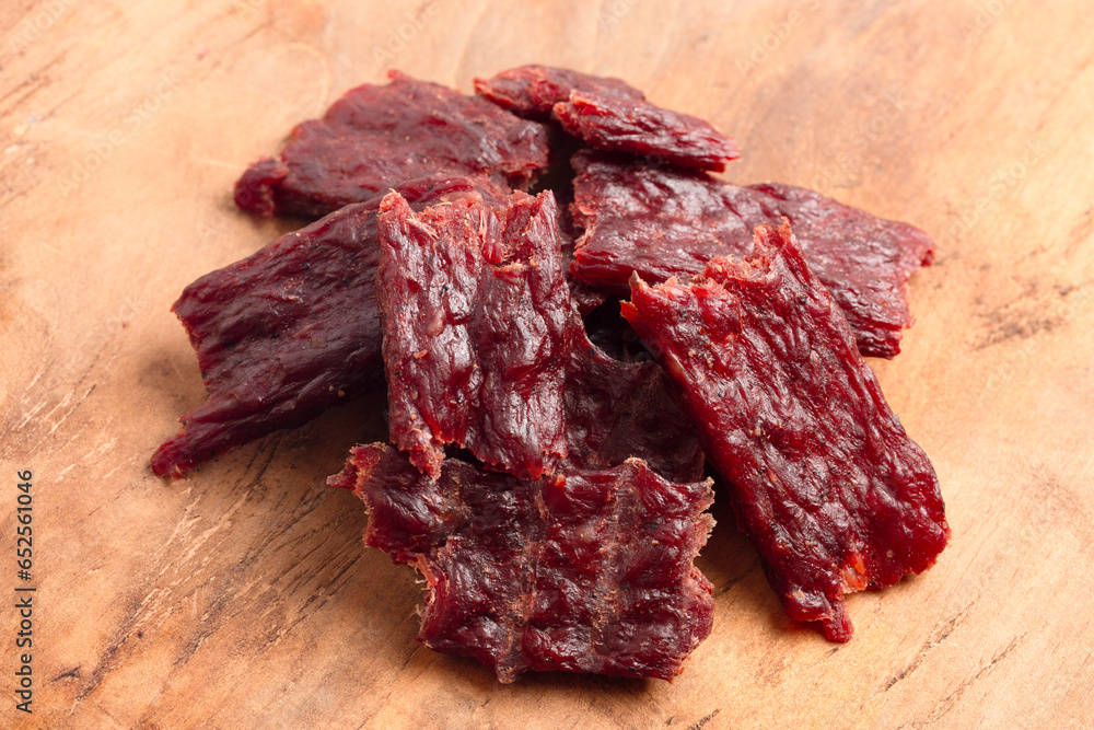 Fototapeta premium Pile of Kippered Beef Steak Beef Jerky on a Rustic Wooden Table