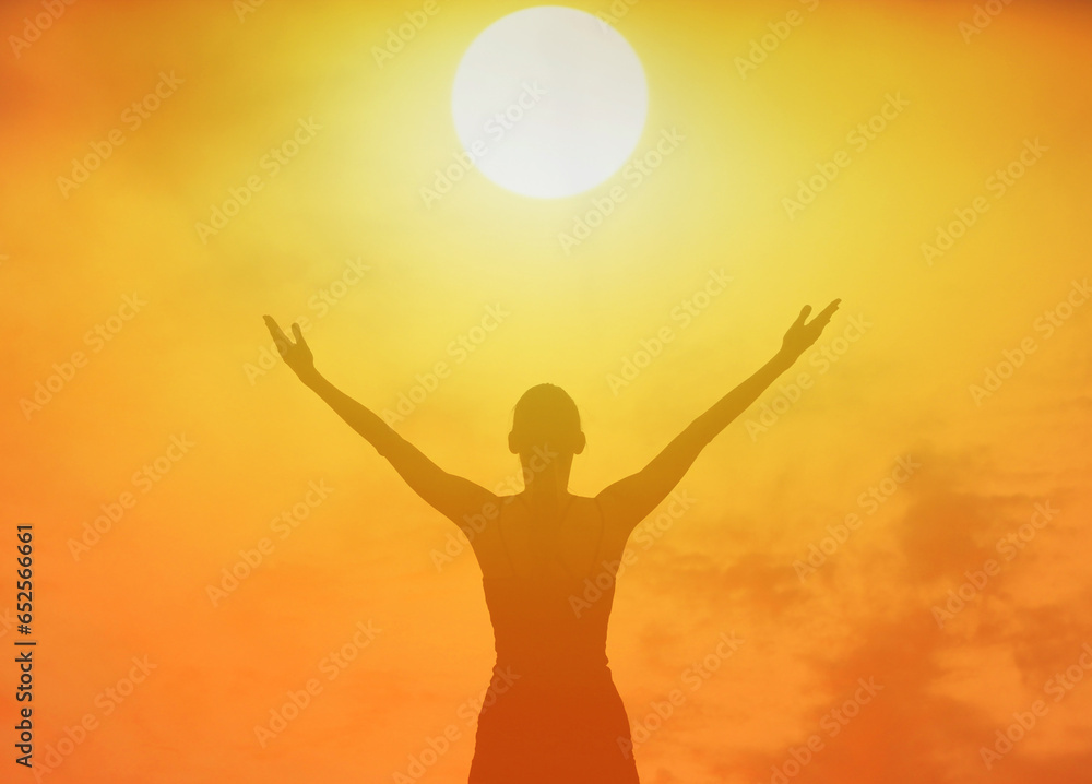 Silhouette of joyful  woman with arms outstretched  up to the sunlight 