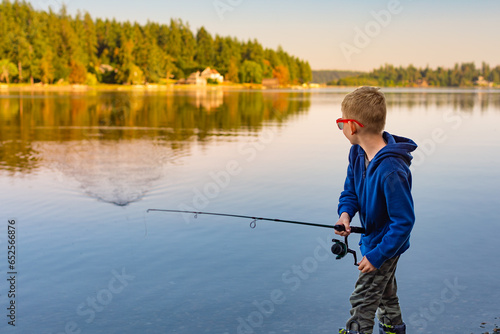 Young boy fishing on a lake enjoying recreational activity 