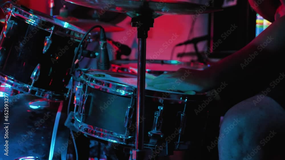 A man playing drums. A drummer beats on a hi-hat and lightly on a working drum with the palm of his hand with a stick. Slow composition. Rock or jazz concert A man playing drums. A drummer beats on a hi-hat and lightly on a working drum with the palm of his hand with a stick. Slow composition. Rock or jazz concert