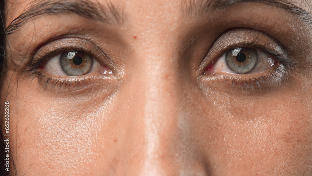 Fototapeta premium Beautiful person look at camera close up. Young adult woman face portrait. Stylish 30 years old girl on isolated white background. Attractive female feminism model. Modern millennial feminist people.