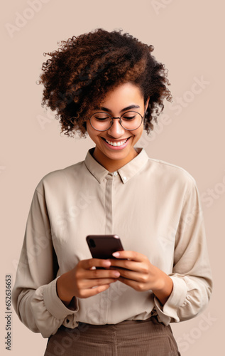 woman of color with curly hair looking at her smartphone with beige background