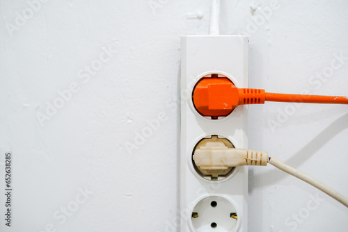 electrical outlet on a wall, electrical power switch, electric plug on a wall, orange electrical plug