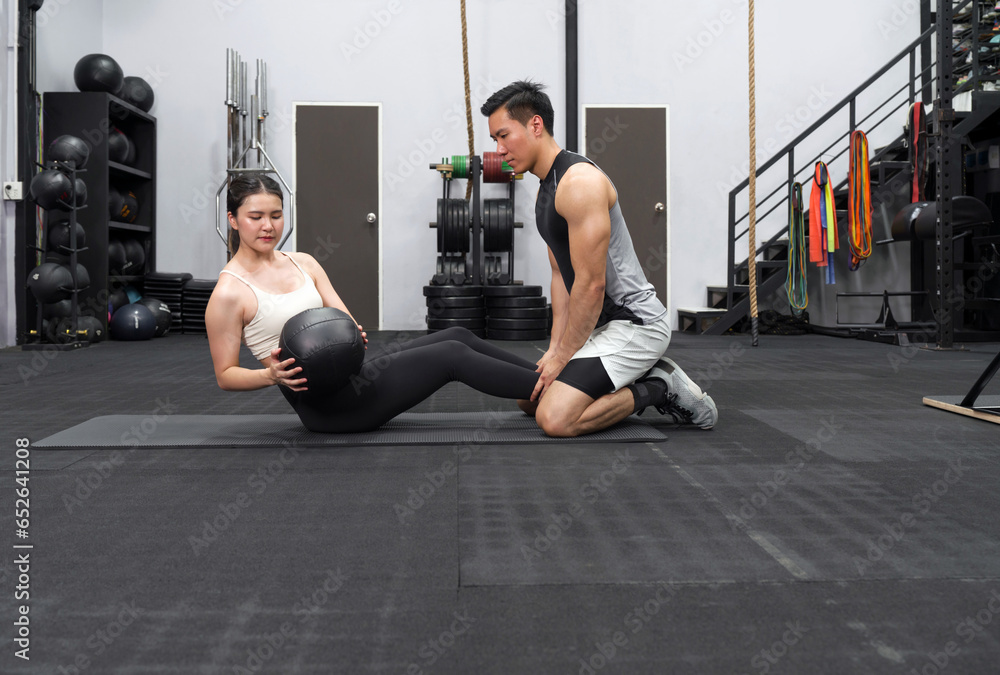 A fit couple engaging in a workout routine within a well-equipped gym ...