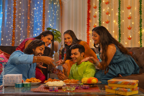 Friends playing cards together at home during Diwali celebration