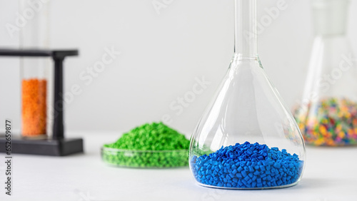 Plastic factory laboratory. Glass flasks with colored dye in granules for plastics. polymer industry.