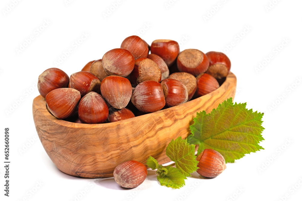 Haselnüsse in einer Holzschale vor weißem Hintergrund Haselnüsse in einer Holzschale vor weißem Hintergrund