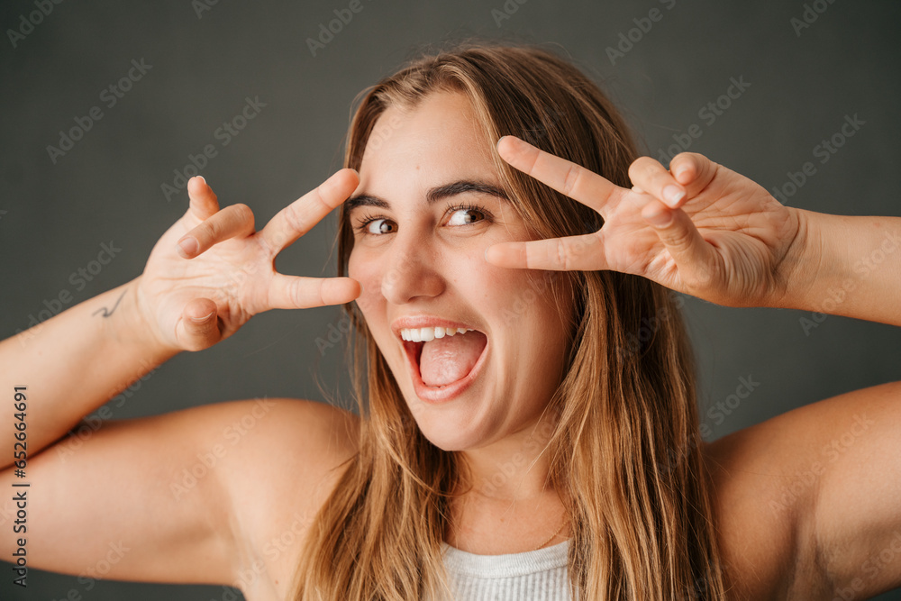 Close up Caucasian female having lots of fun making peace sign symbol Close up Caucasian female having lots of fun making peace sign symbol