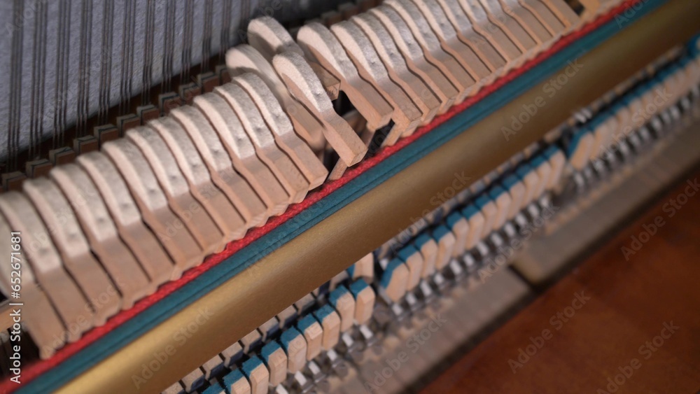 Upright Piano Mechanism Hammers Striking Strings When Song is Played by Musician Upright Piano Mechanism Hammers Striking Strings When Song is Played by Musician