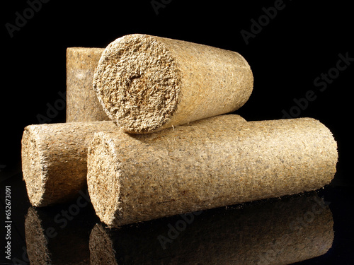 Round Needlewood Sawdust Briquettes - Compressed Biomass Wood Fire Logs isolated on black Background photo