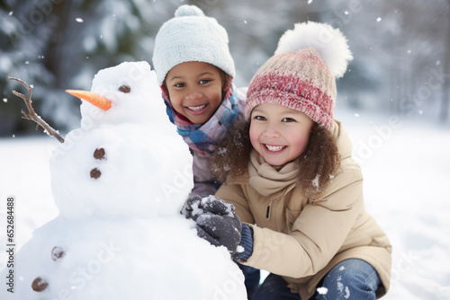 Multiethnic children building snowman at the park in winter