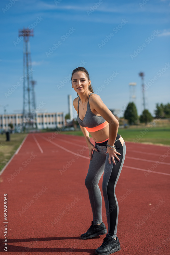 Beautiful woman training on the tracks on a sunny morning