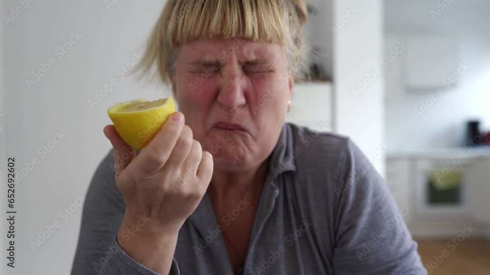 woman bites ripe lemon and makes face woman bites ripe lemon and makes face