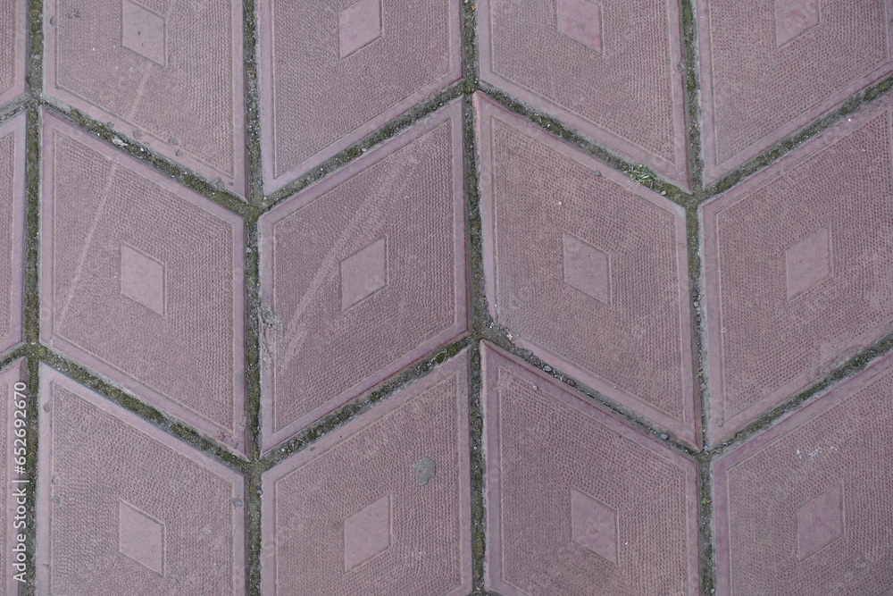 Close up of grayish pink diamond shaped concrete pavement with geometric pattern