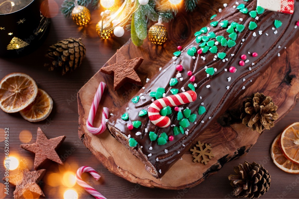 Traditional chocolate trunk cake or log cake on table with Christmas decorations