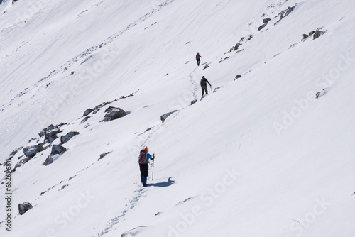team of climbers walking one after the other towards the summit