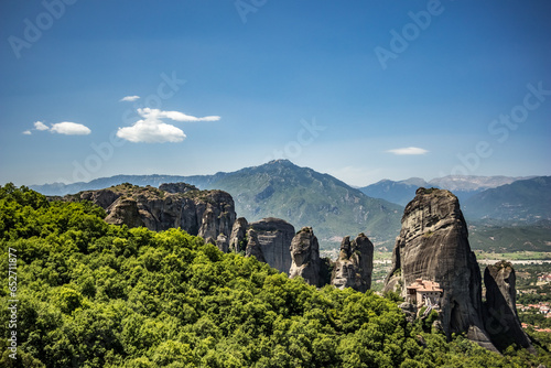Scenery warm day travel view from Meteora, Greece with slight white clouds in the crystal blue sky. Place of pilgrimage, Orthodox Christianity