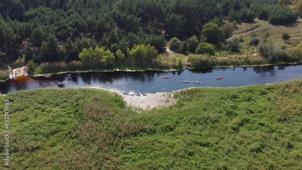 Drone video recording of kayaks leaving the starting point. The river serves as the border between the forest and the swamps. Drone video recording of kayaks leaving the starting point. The river serves as the border between the forest and the swamps.
