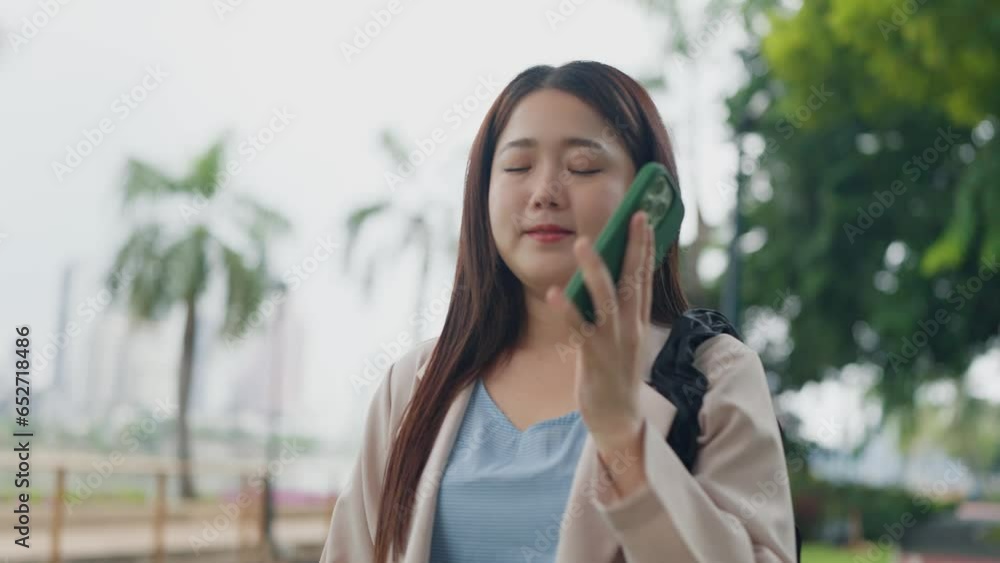 Beautiful young Asian woman talking on smartphone while walking at outdoors. Happy Asian women talking through smartphone. Lifestyle concept Beautiful young Asian woman talking on smartphone while walking at outdoors. Happy Asian women talking through smartphone. Lifestyle concept