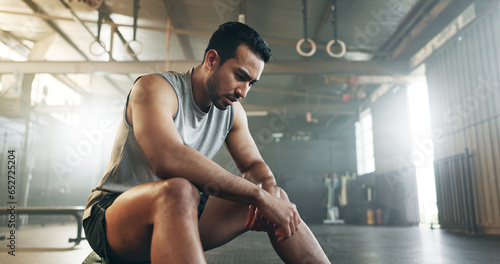 Fitness, breathing and sweating with a tired man in the gym, resting after an intense workout. Exercise, health and fatigue with a young athlete in recovery from training for sports or wellness photo