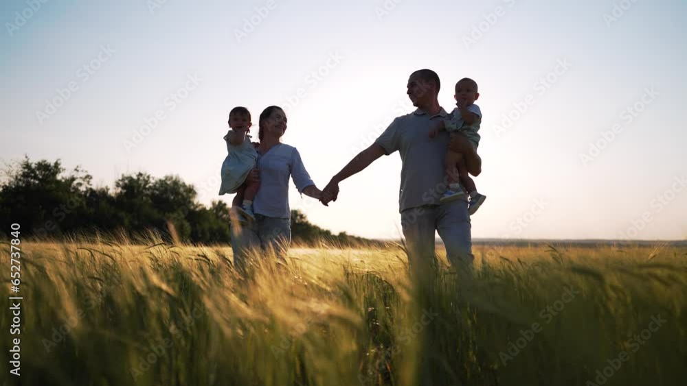 Happy family.group of people walk together holding hand in wheat field at sunset.family hold babies in their arms.Family day outdoors in summer in wheat field.Silhouette of happy family in wheat field Happy family.group of people walk together holding hand in wheat field at sunset.family hold babies in their arms.Family day outdoors in summer in wheat field.Silhouette of happy family in wheat field