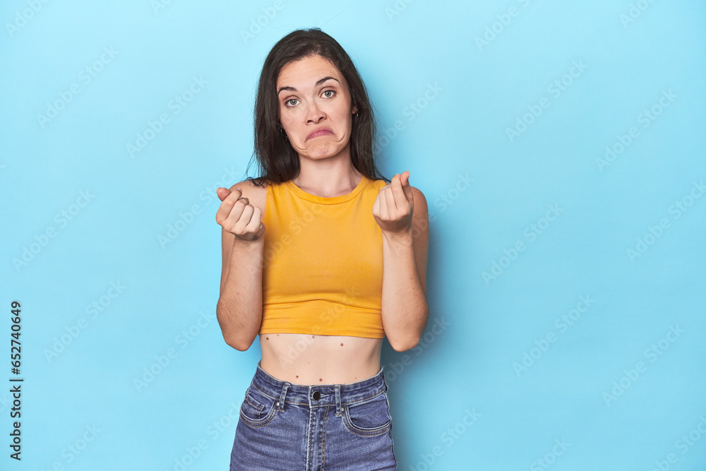 Young caucasian woman on blue backdrop showing that she has no money.