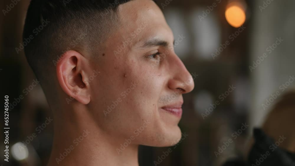 Side view closeup face of smiling Middle Eastern man shaping eyebrows as unrecognizable blurred Caucasian woman in gloves plucking with tweezers at background. Male beauty and pampering Side view closeup face of smiling Middle Eastern man shaping eyebrows as unrecognizable blurred Caucasian woman in gloves plucking with tweezers at background. Male beauty and pampering