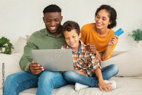Diverse Family Shopping Online Using Laptop And Credit Card Indoor