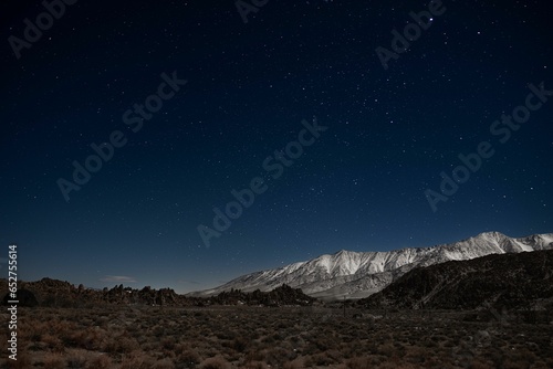 Landscape with snow covered mountains and starry sky in the background