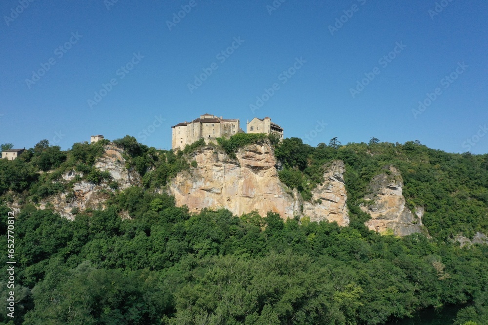 View of Bruniquel castle in scenic green terrain, France