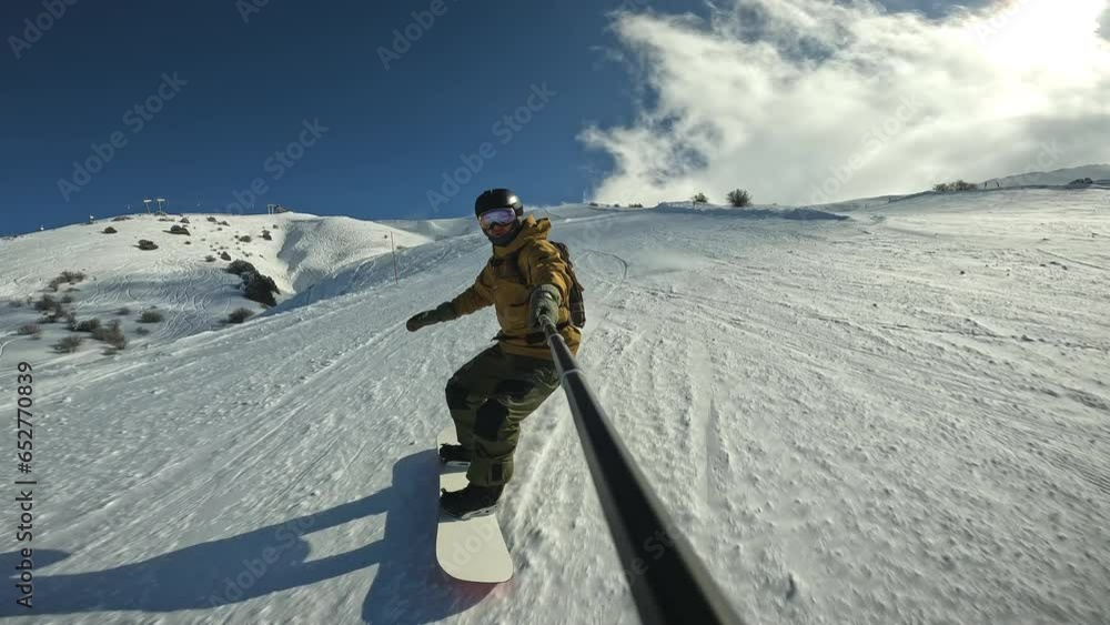 Snowboarder rides through snow and turns in fresh powder Snow splashes into athlete in wave Snowboarder wearing protective suit and goggles with helmet designed to protect snowboarder snow and falling