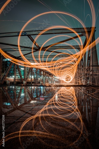Motion blur effect of glowing light trails on a night downtown background © Iamalexanderlosch/Wirestock Creators
