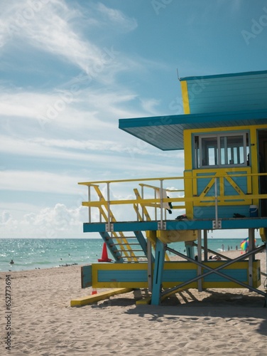 Vibrant lifeguard tower on a beach with pristine white sand stretching out to a calm blue ocean