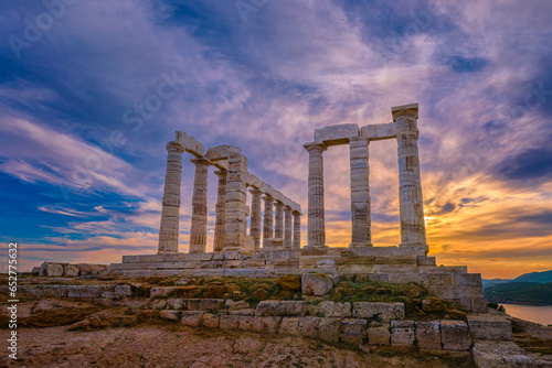Sunset sky and ancient ruins of temple of Poseidon, Sounion, Greece