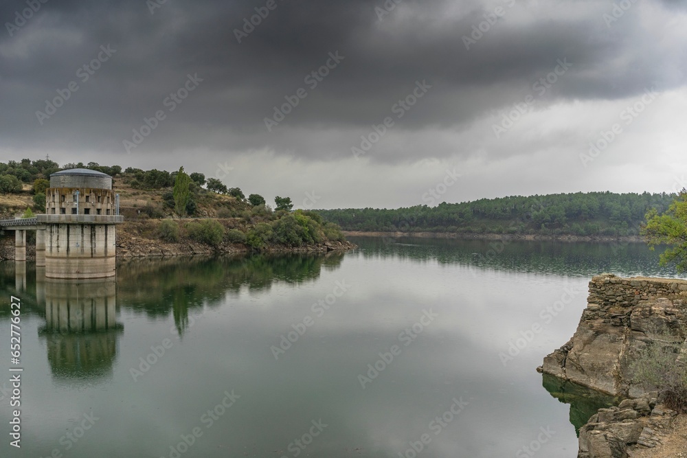 El Villar reservoir in the mountains of Madrid on a day with overcast skies and clouds