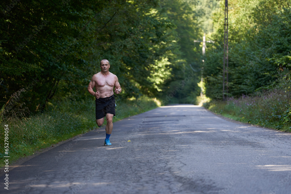 Athletic shirtless man running on road Athletic shirtless man running on road