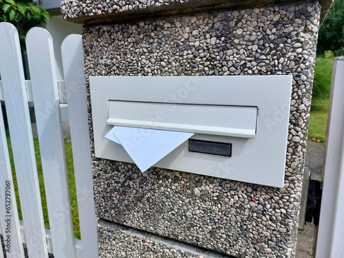 postbox on white fence - letters in mailbox