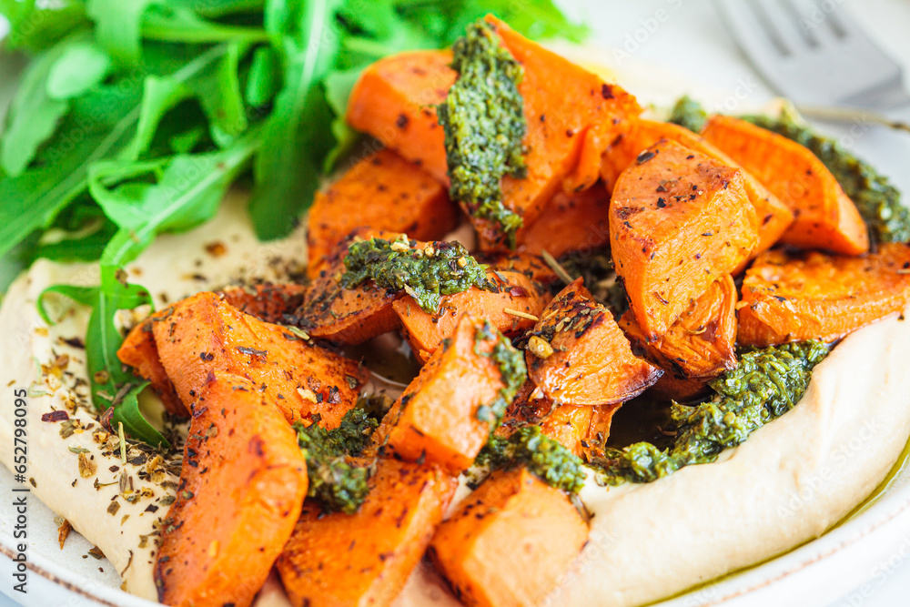 Vegan lunch - hummus, baked sweet potato and pesto, white background. Vegan lunch - hummus, baked sweet potato and pesto, white background.