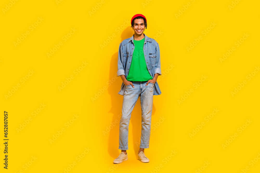 Full body photo of attractive young man hands pockets pants shopping posing wear trendy jeans clothes isolated on yellow color background Full body photo of attractive young man hands pockets pants shopping posing wear trendy jeans clothes isolated on yellow color background