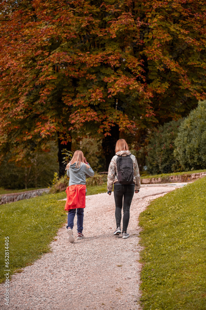 Fototapeta premium Mother and daughter are walking in autumn time. 
