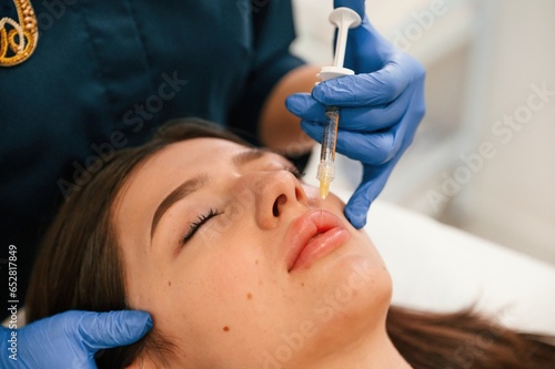 Cosmetologist does injection for lips augmentation. Women's cosmetology in the beauty salon