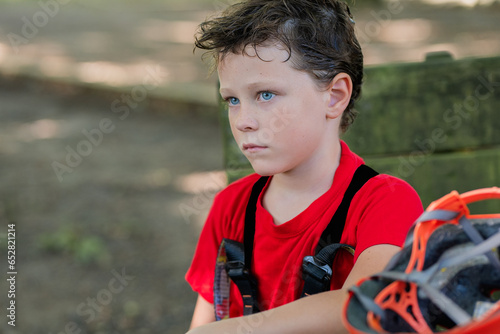 Child resting in a forest adventure park. Outdoor entertainment.