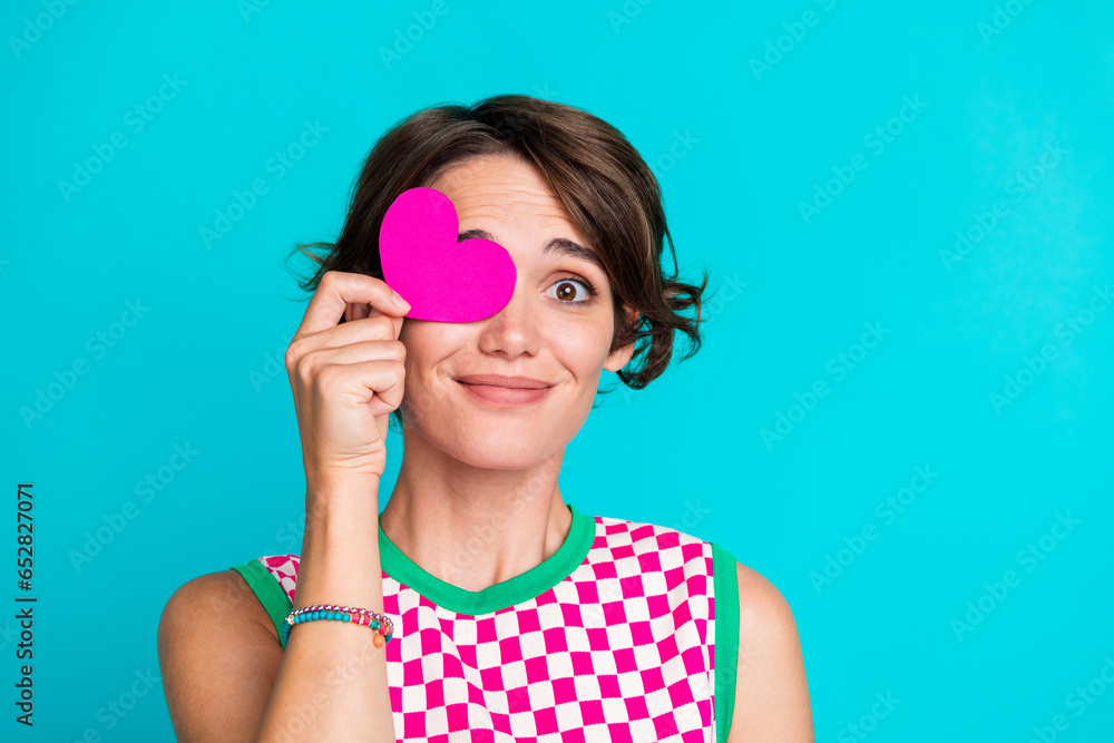 Photo of cute lovely young girlfriend holding paper heart shape symbol miniature postcard hide eye isolated on aquamarine color background Photo of cute lovely young girlfriend holding paper heart shape symbol miniature postcard hide eye isolated on aquamarine color background