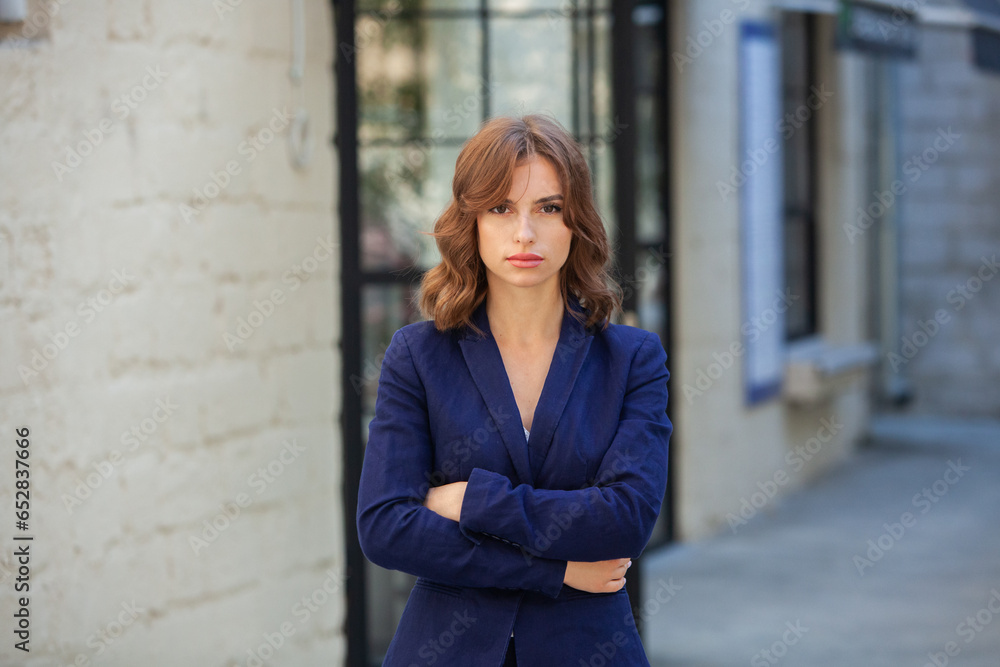 Portrait of a successful business woman in front of modern business building. Young manager poses outside. Woman employee of an office. Portrait of a successful business woman in front of modern business building. Young manager poses outside. Woman employee of an office.