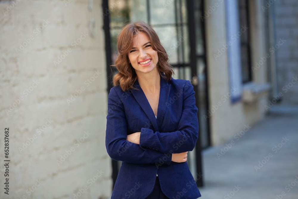 Portrait of a successful business woman in front of modern business building. Young manager poses outside. Woman employee of an office. Portrait of a successful business woman in front of modern business building. Young manager poses outside. Woman employee of an office.