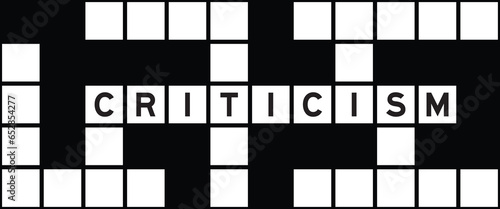 Alphabet letter in word criticism on crossword puzzle background